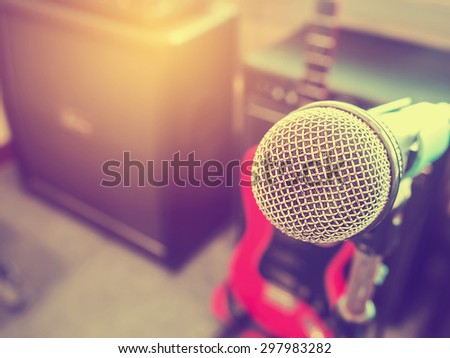 Microphone in a recording studio or concert hall with amplifier in out of focus background. : Vintage style and filtered process.