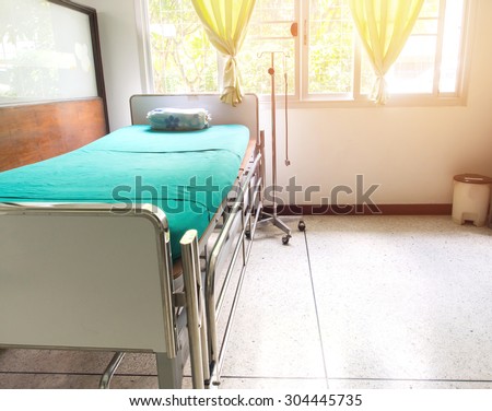 A single hospital bed or examination couch waiting the next patient in empty room.