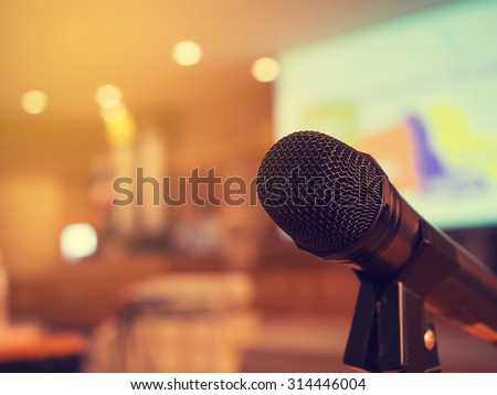 Black microphone in concert hall or conference room with defocused bokeh lights in background. Extremely shallow dof. : Vintage style and filtered process.