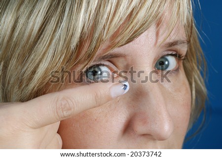 woman sets contact lens into eye
