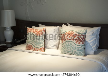 Image of comfortable pillows and bed in the low light