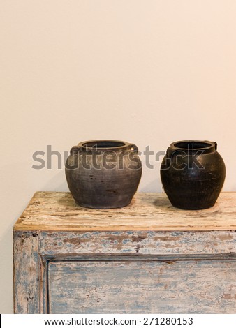 two empty pots in ethnic style on wooden old-looking cupboard