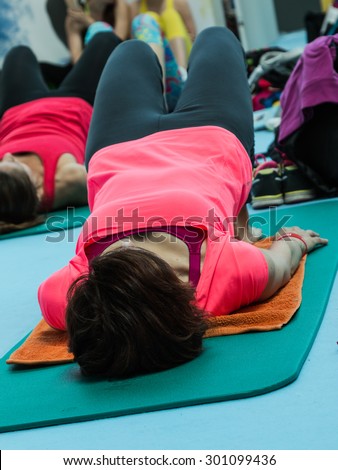Women Pilates Exercises on Rubber Mat In Gym