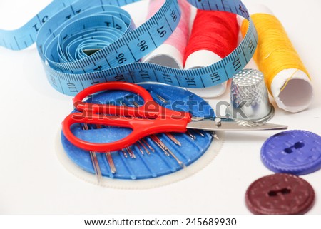 Sewing tools: tape measure, bobbins on a white background