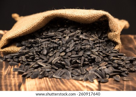 Sunflower seeds in bag on wooden background