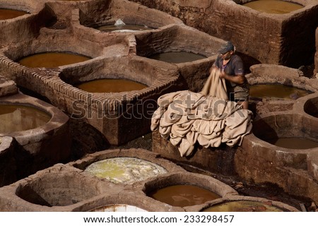 Fez, Morocco - April 10, 2014: Unidentified Man are working in the  traditional tannery of the fez city. / Tannery in Fez, Morocco