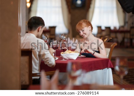 Attractive casual young couple drinking a glass of wine in a restaurant. Lovers having a date or romantic dinner in a fancy restaurant