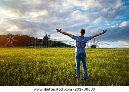 Man on nature background with arms outstretched. Free man