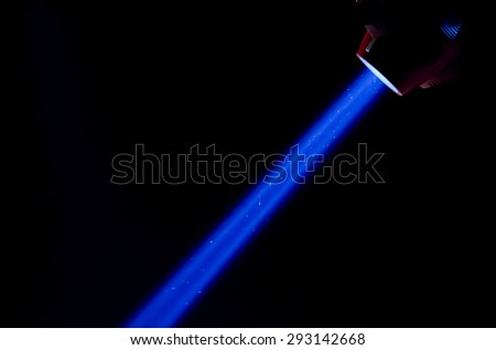 Beam of blue light on black background. Applied to a searchlight, torch.