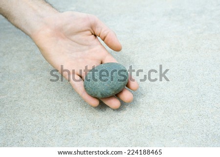 Man holding pebble in hand, cropped view