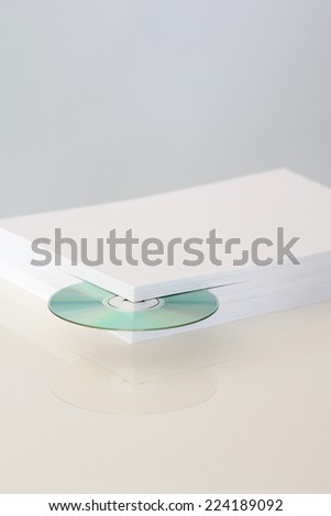 Stack of paper with CD emerging from the corner