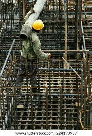 Worker wearing hard hat, holding pipe