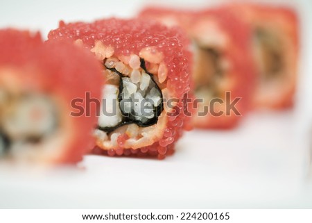 Cropped view of maki sushi rolled in red flying fish roe, close-up