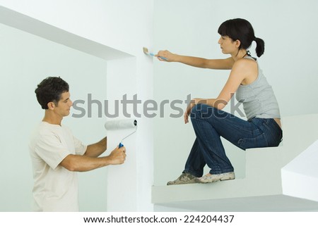 Man and woman painting home interior