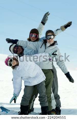 Young skiers standing on ski slope, full length portrait