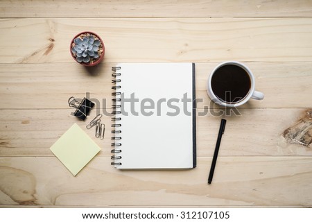 blank opened notebook with cup of coffee and memo note on wooden table. Top view. Writing concept