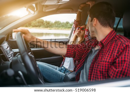 Couple sitting in the car listening to music and having fun. Enjoy a fun journey