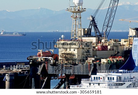 GENOA, ITALY - FEBRUARY 28, 2014: CASTORO6, a platform of Saipem in support of oil drilling at sea, 152 meters long and 70 wide with a gross tonnage of 31,000 tons.  The Ligurian coast at horizon.