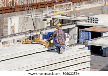 GENOA, ITALY - MARCH 2014: Construction workers to work in a large urban yard. Security and compliance.