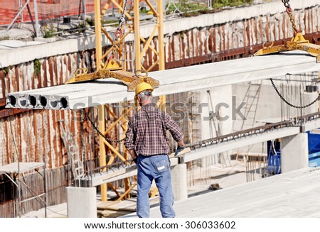 GENOA, ITALY - MARCH 2014: Construction workers to work in a large urban yard. Security and compliance.