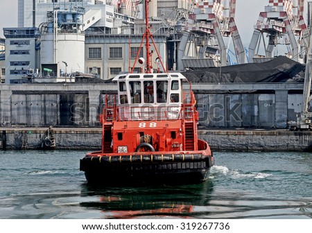GENOA, ITALY - FEBRUARY 22, 2010: The tug BRASILE maneuvering in the industrial area of the port of Genoa.