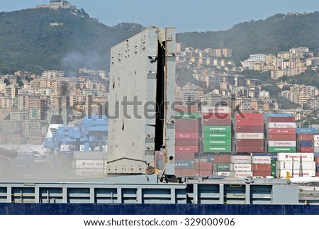 GENOA, ITALY - SEPTEMBER 24, 2015: Cleaning of the holds of a cargo ship. Cement dust in the air. In the picture, pollution and fine dust in the air of the city of Genoa.