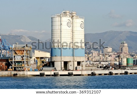 GENOA, ITALY - JANUARY 21, 2016: Silos on the commercial dock of the port. In the picture, the quay with silos and in the background the city of Genoa.