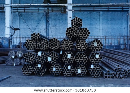 Metal pipes in a warehouse. Stacks of new round steel pipe in factory. Toned in cold tone