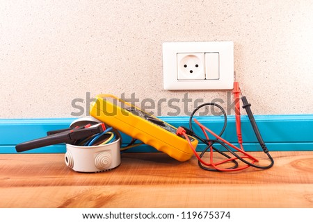 Multimeter, electrical box, wire stripper in the room