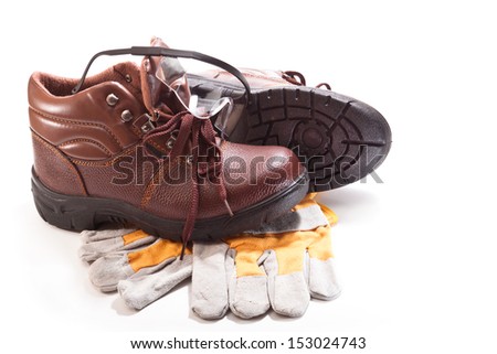 Brown work boots, gloves and goggles for safe operation on a white background