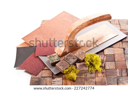 Tiles made of wooden blocks,trowel, sandpaper and moss on a white background