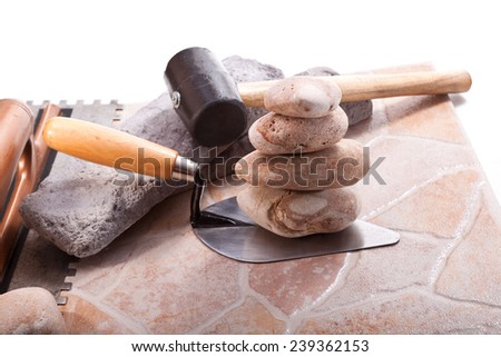 Tiles, stack stone, trowel and spatula on a white background