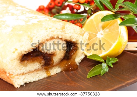 cake on a wooden platter with lemon and a glass of tea