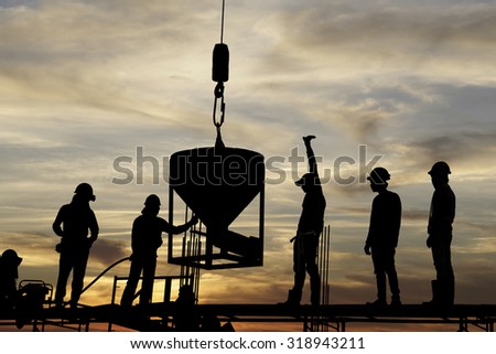 silhouette of construction worker stand on scaffolding  framework casting concrete column  in construction site during beautiful sunset
