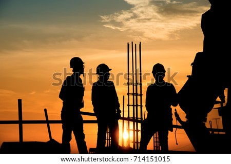 Silhouette worker civil engineer and safety officer in  industrial sector construction over blurred natural background sunset success team work business concept