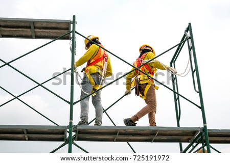 Workers  safety uniform on scaffolding,copy space.beautiful background in construction site