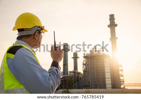 Manager Engineering in standard safety uniform working in gas turbine electric power plant  during sunset or morning time background