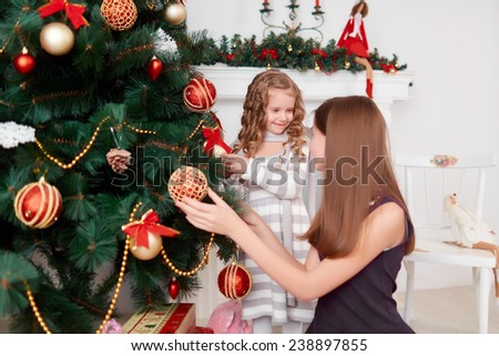 Two cute little sisters decorate a Christmas tree. Christmas mood