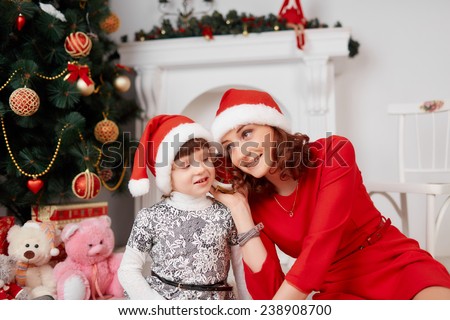 Happy family mother and baby in red Christmas hats. Happy family mother and baby little daughter playing in the winter for the Christmas holidays.