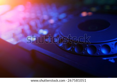 DJ mixer with light colored spotlights discos, shallow depth of field and beautiful swirling bokeh