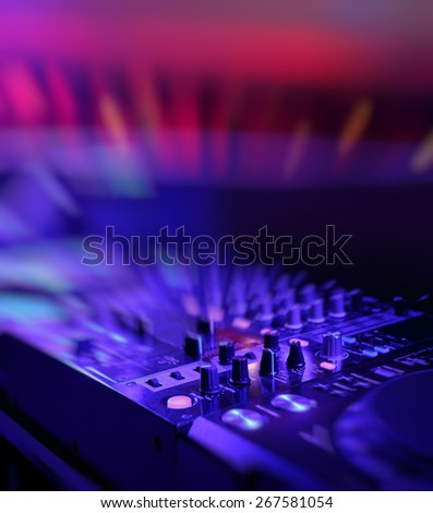 DJ mixer with light colored spotlights discos, shallow depth of field and beautiful swirling bokeh
