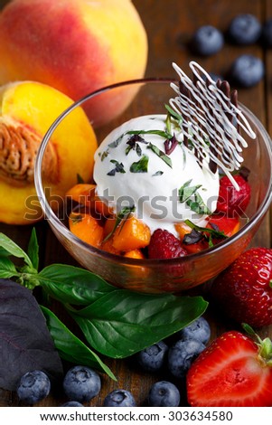 Ice cream ball with fresh fruits in glass bowl on wooden table