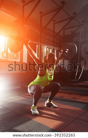 Muscular fitness woman deadlift a barbell over his head crossfit in the gym. Sports, crossfit and fitness - concept of healthy lifestyle. Woman in the fitness club. Crossfit woman. Crossfit style
