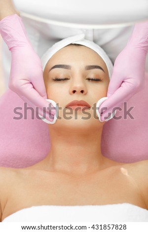 Face Lifting. Young woman getting facial massage in the cosmetology salon. Procedure of facial massage in cosmetology. Face Skin Care. Lifting Procedure. Cosmetology Salon. Cosmetology Face Massage.