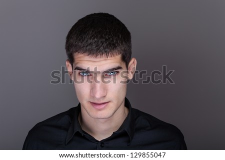 Portrait of handsome young man. Dark background.