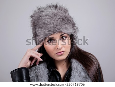 Portrait of beautiful girl with the winter hat on. Fur Fashion Hat.