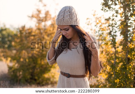 Beautiful young woman wearing fashion autumn clothes. Outdoor portrait in a autumn scenery.