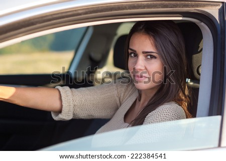 Pretty young woman driving her new car. Portrait of beautiful young Caucasian woman in car.