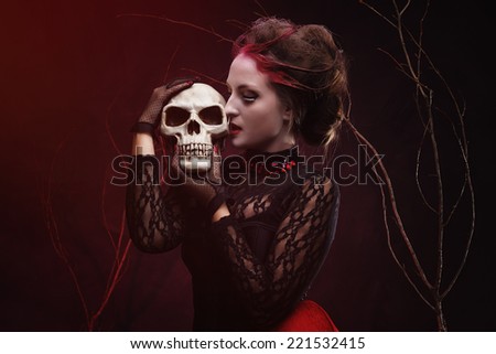 Beautiful witch with a bone in mystery forest. Halloween make-up and costume.