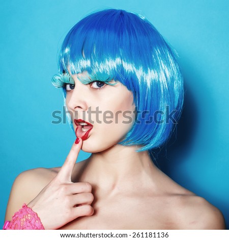 Fashion beautiful woman in pink bodysuit with blue hair and trendy hairstyle on a blue background. Perfect body. Disco punk fashion style club Party Girl